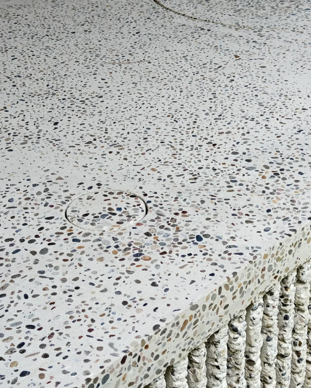 The circular terrazzo recess for the barbecue, closed flush with the counter